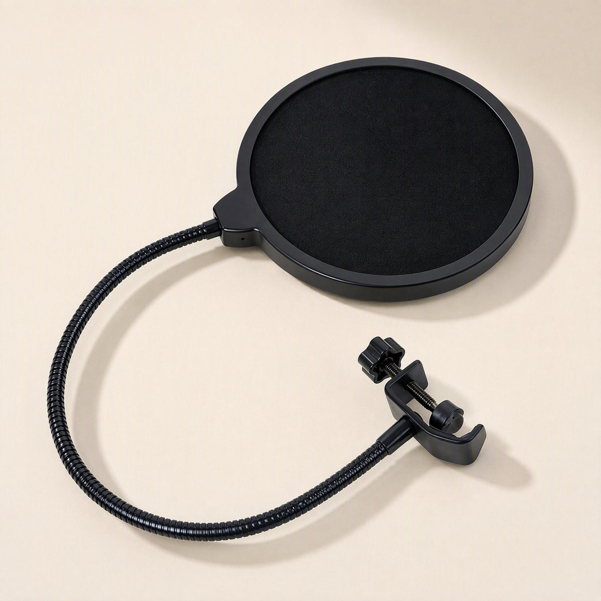 Streamveil – Angled view of the round mesh screen with curved gooseneck and clamp resting on a cream surface