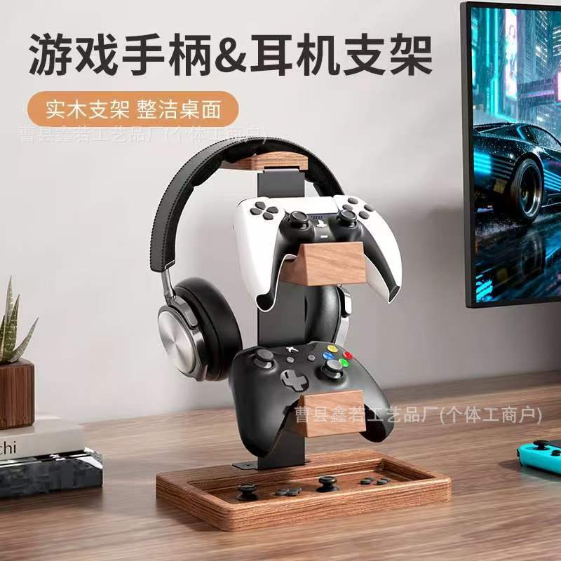 Timberhold Solid Wood Headphone Stand holding headphones and two game controllers on a desk beside a monitor