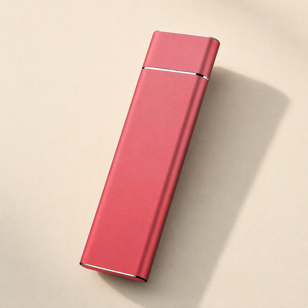 Driveglide – Red metal portable drive lying flat on a cream surface, with a silver trim line near one end