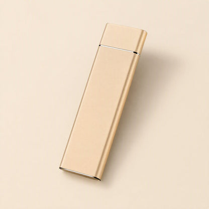 Driveglide – Gold-toned slim metal drive angled on a pale beige background, USB port end at the bottom