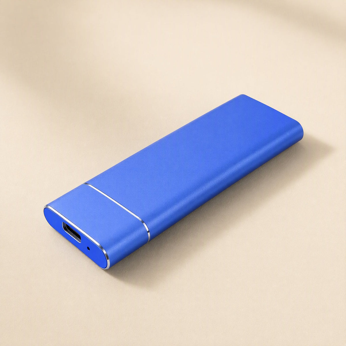 Roamdrive Portable Solid State Drive – blue metal portable SSD angled to show its USB-C port on a beige background