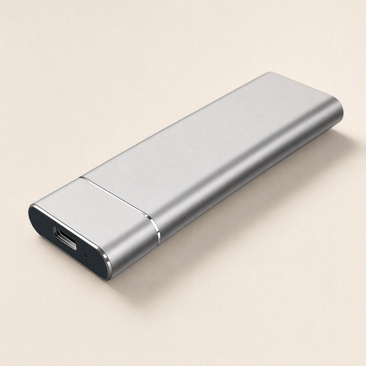 Roamdrive Portable Solid State Drive – silver-gray metal portable SSD with a USB-C port on a cream background