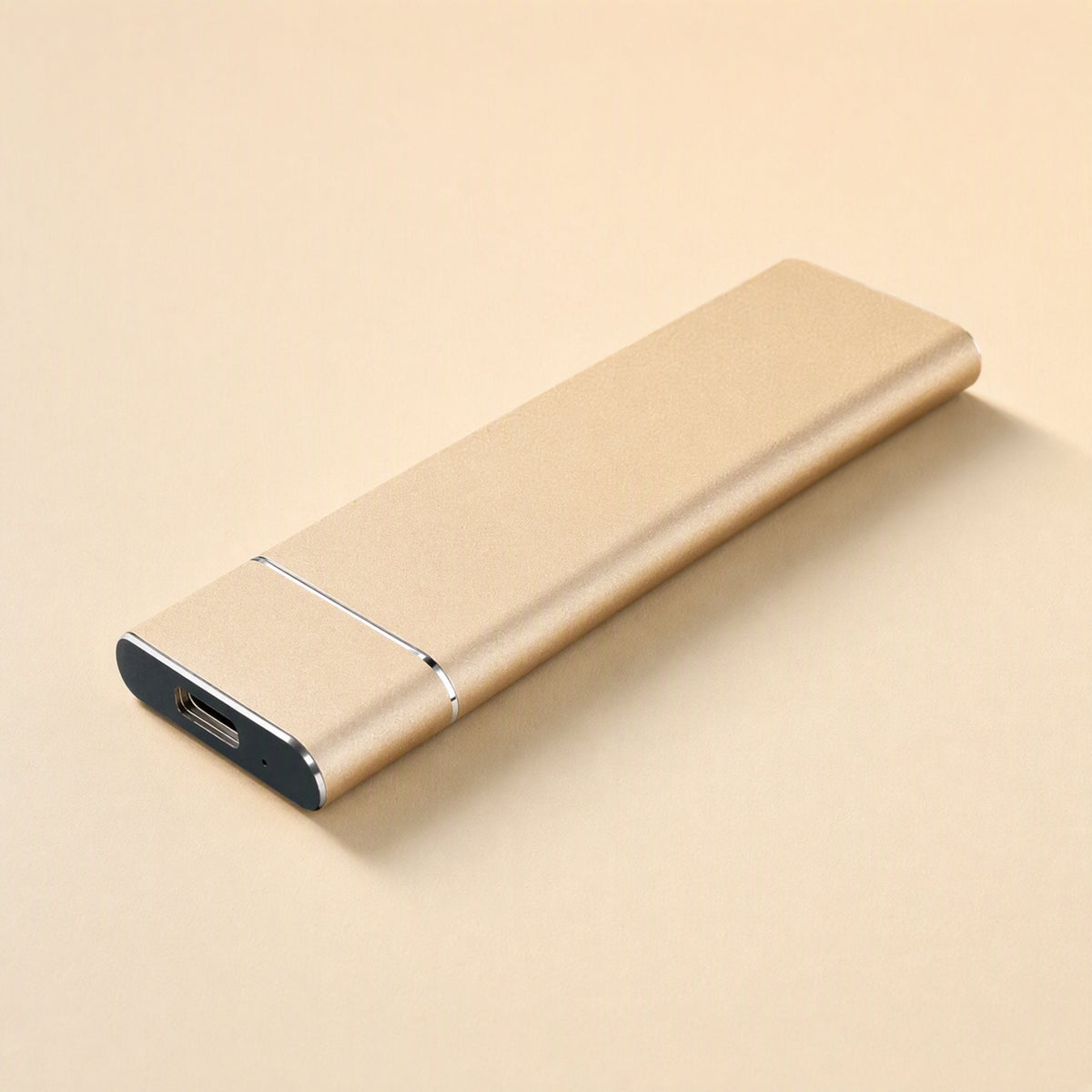 Roamdrive Portable Solid State Drive – gold metal portable SSD lying at an angle, USB-C port facing the front corner