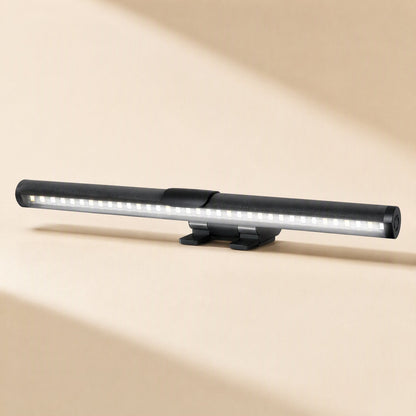 Screenlamp – Cylindrical black light bar with visible rows of small LEDs and a dual-leg clip base on a beige surface