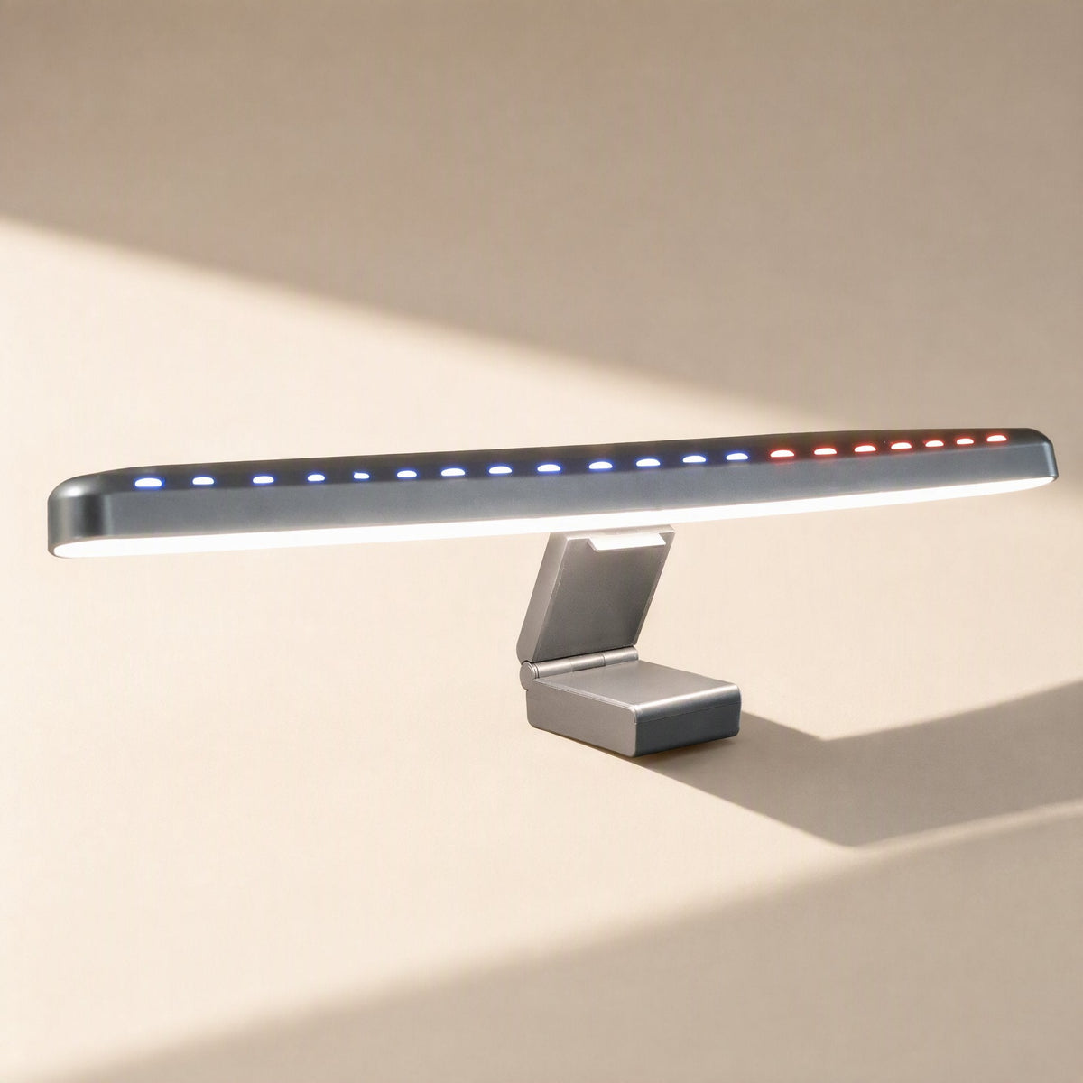 Screenlamp – Silver-gray monitor light with a flat bar, colored indicator dots along the top and a folding clip stand
