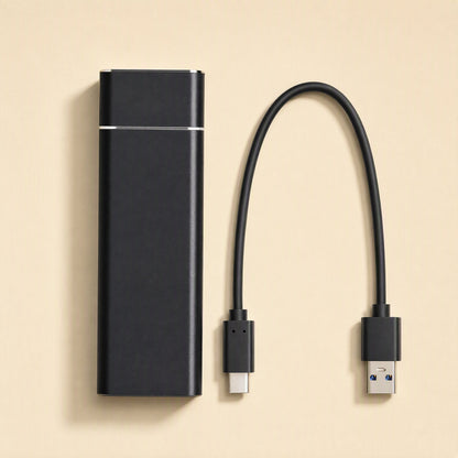 Drivevault – Black portable drive beside a detachable USB-C to USB-A cable on a beige background