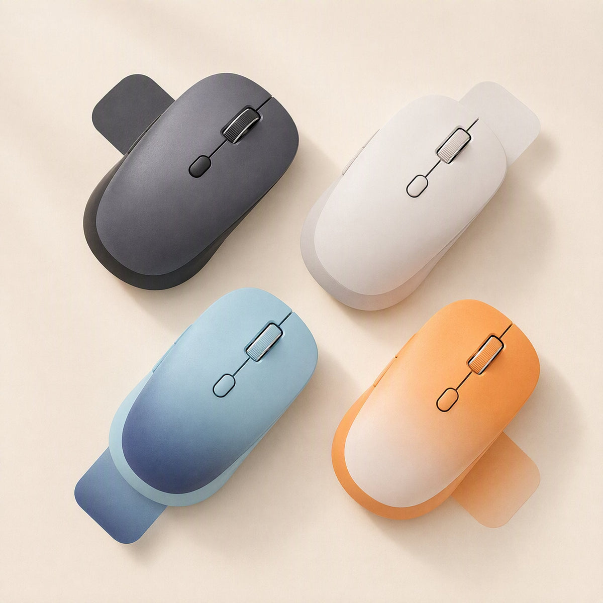 Twintrack – Top-down view of four wireless mice in gray, white, blue and orange gradient finishes with beige tabs