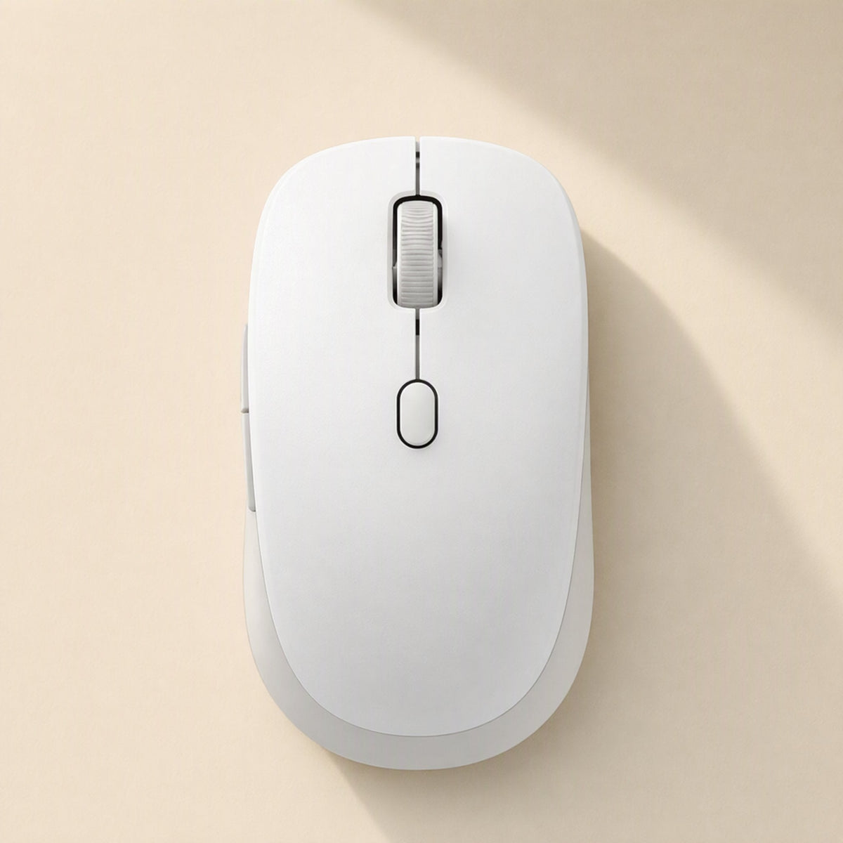 Twintrack – White wireless mouse seen from above, showing the scroll wheel and center button on a cream background