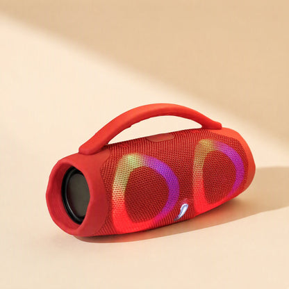 Portatune – Red speaker with carry handle lying on its side, pastel pink and yellow light rings and a small white indicator