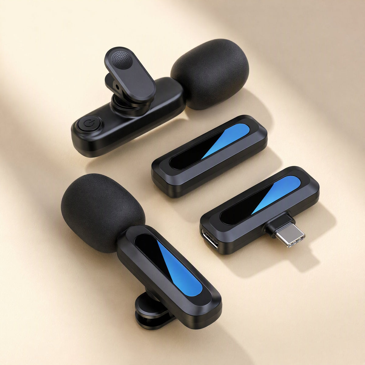 Livevoice – Two clip-on microphones with black foam windscreens beside two receivers, one with a USB-C plug, on a beige