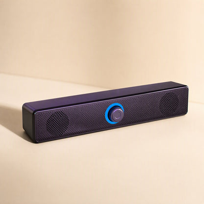 Tinytone – Purple-black long-strip speaker at a low angle, with a blue-ringed center knob and mesh grille