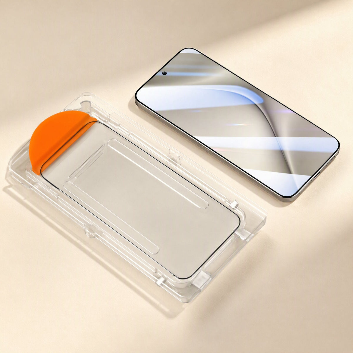 Clearshield Tempered Glass Screen Protector in a clear alignment frame with orange tab beside a phone