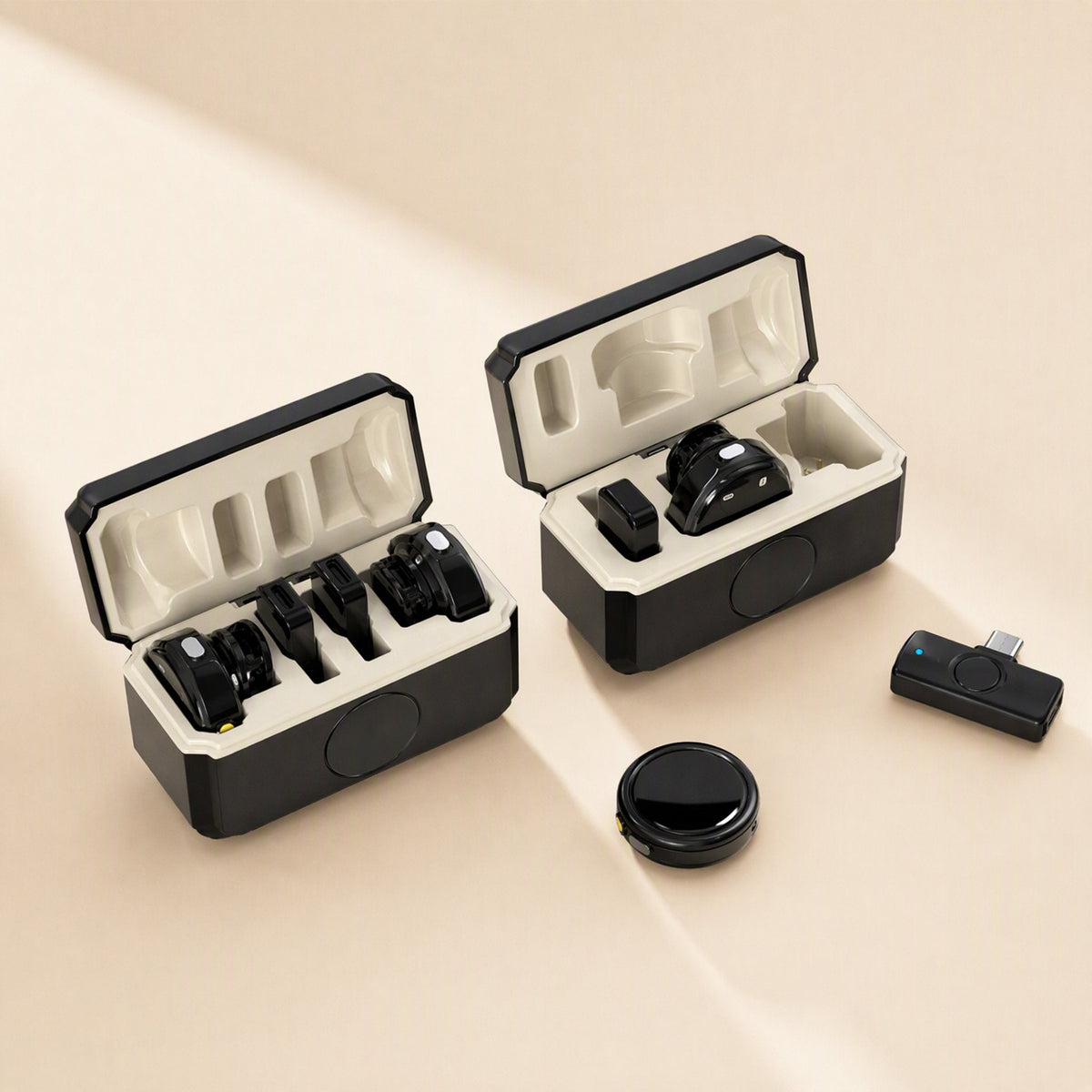 Lapelcast – Two open cream-lined charging cases with clip mics, a USB-C receiver and a round magnetic mic