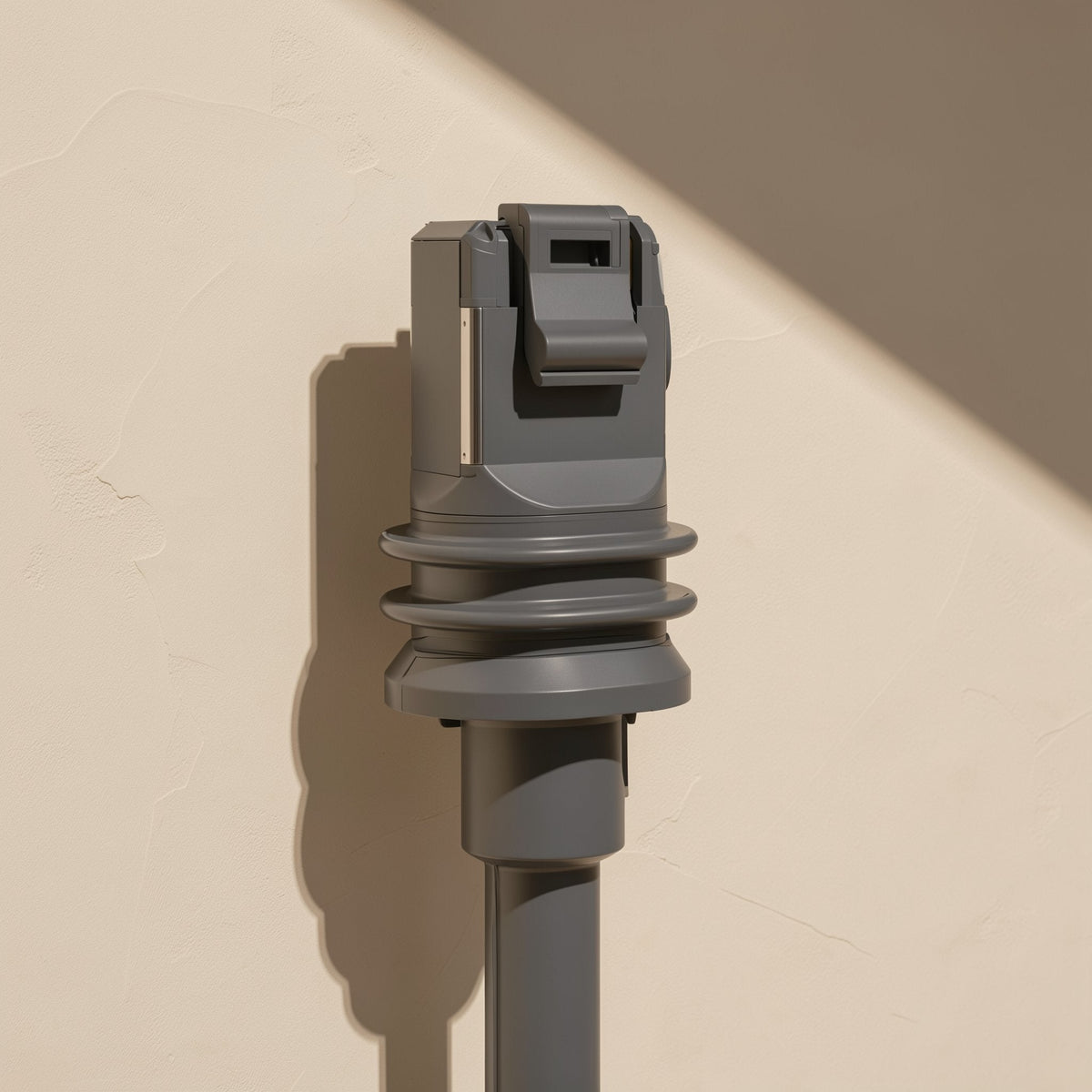 Databraid – Front view of a gray RJ-45 plug with latch tab and ribbed boot, standing upright against a beige wall