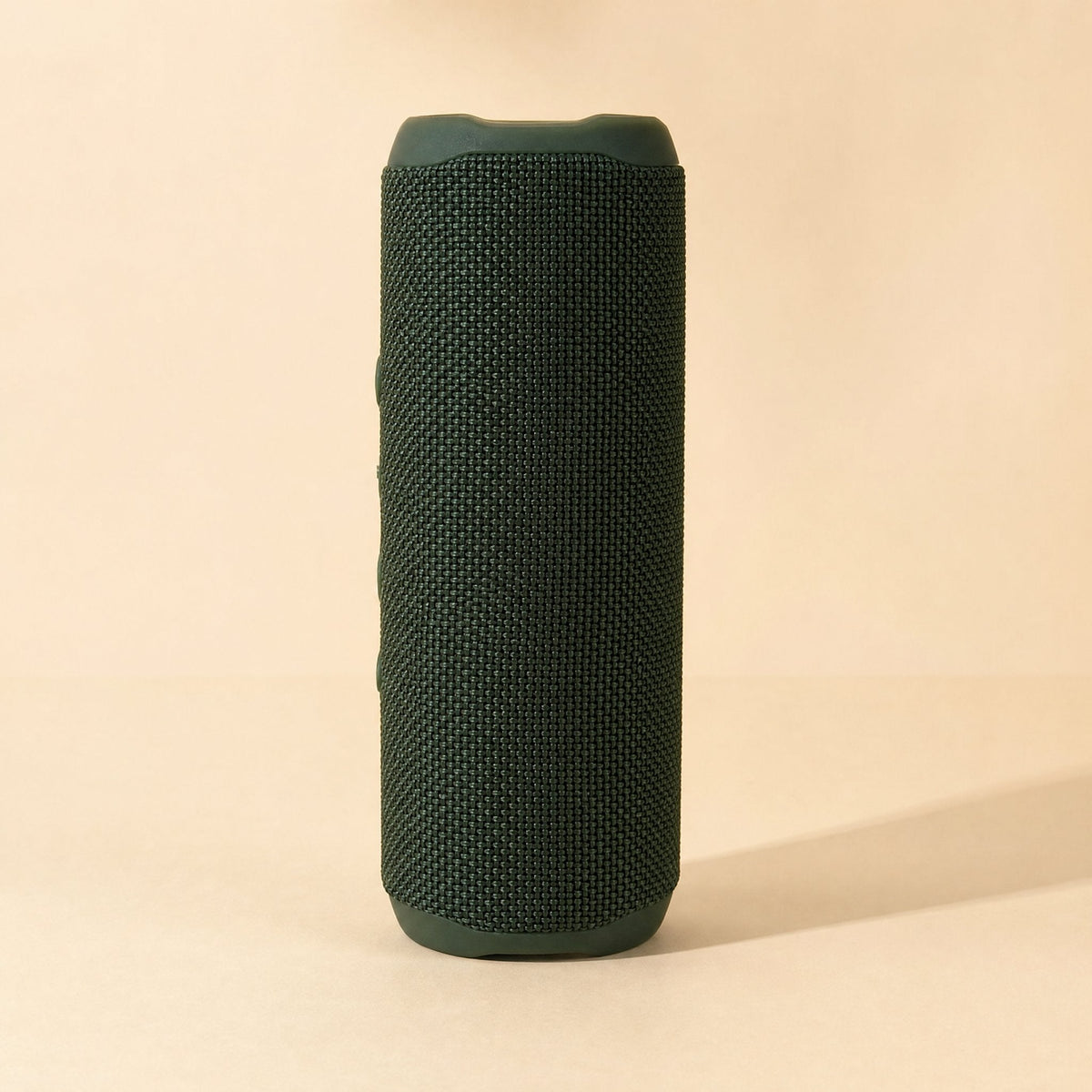Splashbeat Bluetooth speaker with IPX3 rating, upright in dark green woven fabric on a cream background