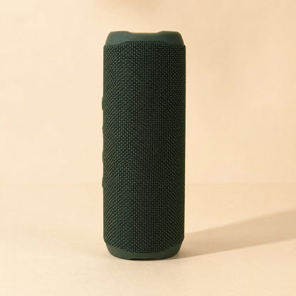 Splashbeat Bluetooth speaker with IPX3 rating, upright in dark green woven fabric on a cream background