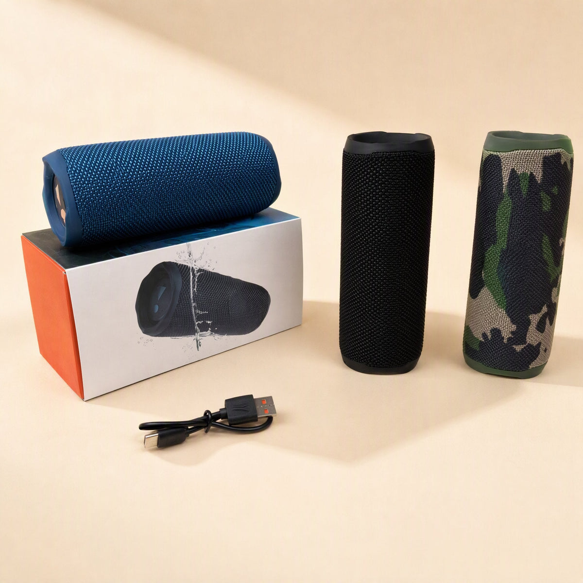 Splashbeat – Blue speaker on its box next to upright black and camo speakers, with a USB-C charging cable