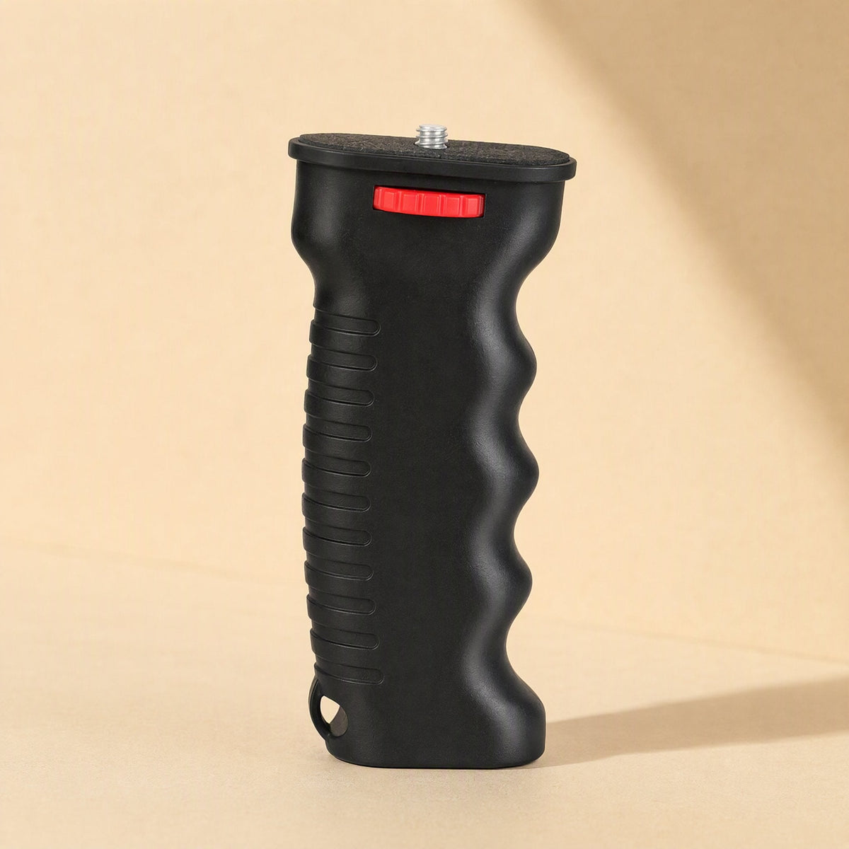 Steadyshot – Side view of the black plastic grip showing ribbed back, finger grooves and strap hole at the base