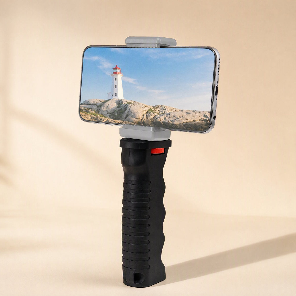 Steadyshot – Grip holding a smartphone in landscape with a lighthouse photo on screen, mounted via a gray clamp