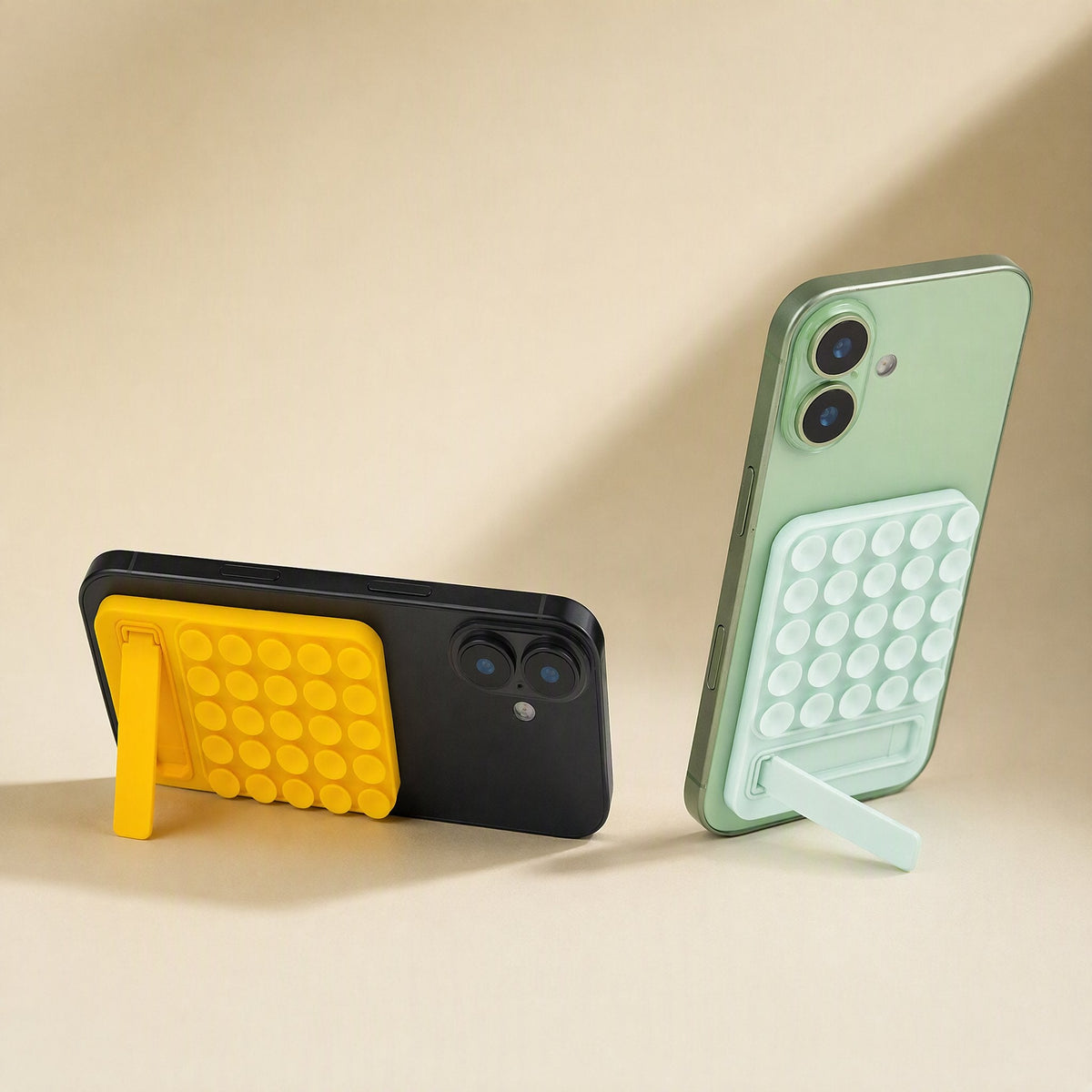 Suctionnest – Yellow and mint green suction cup holders on the backs of phones, kickstands propped open