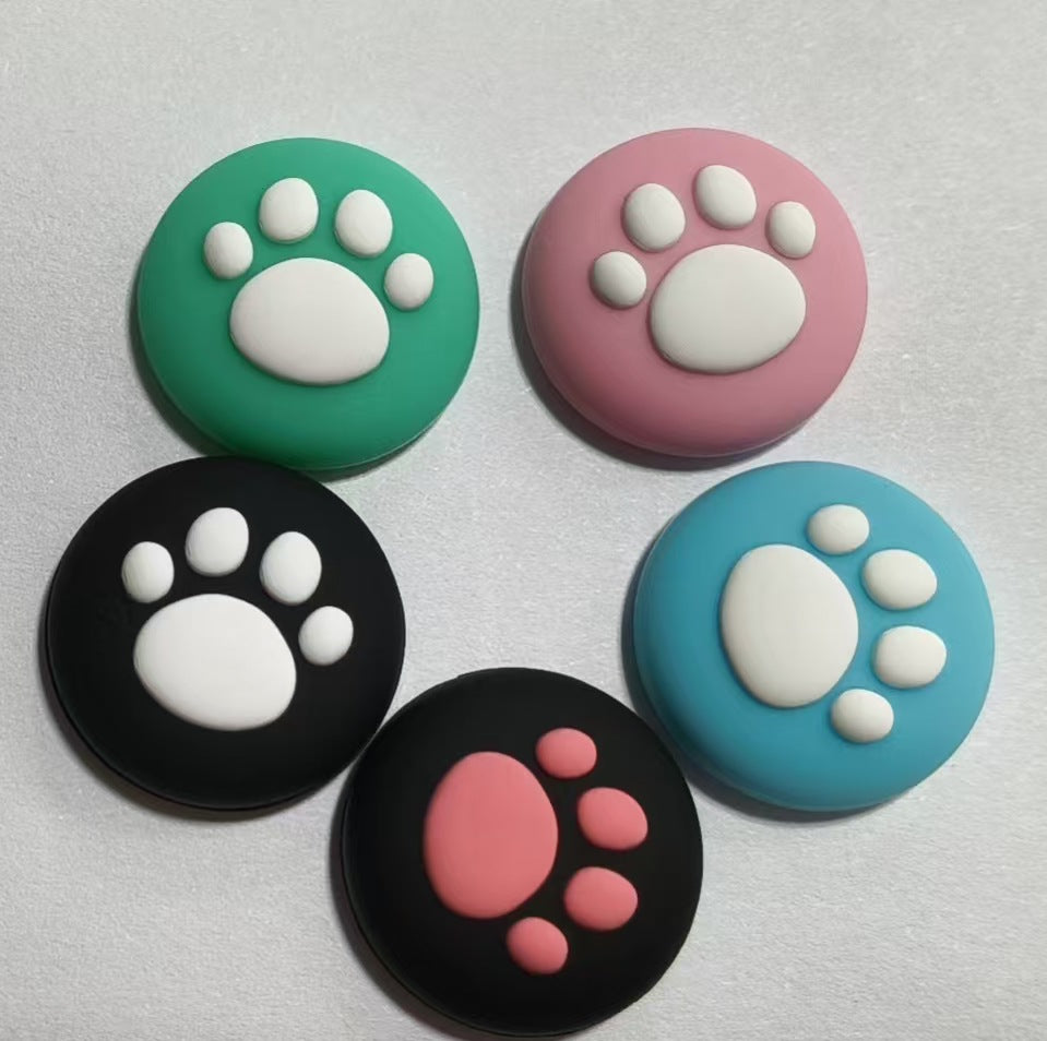 Pawcap – Five cat paw joystick caps in green, pink, black, light blue and black with a pink paw, on grey