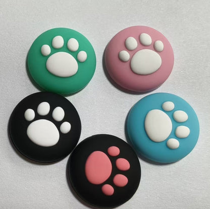 Pawcap – Five cat paw joystick caps in green, pink, black, light blue and black with a pink paw, on grey