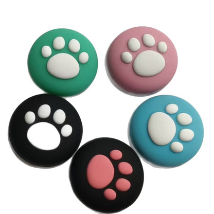 Pawcap – Five cat paw joystick caps in a ring on white, with one black cap showing a hollow white paw