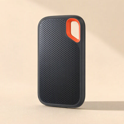 Roamdisk Solid-State Mobile Hard Drive standing upright, showing perforated black front and orange loop corner