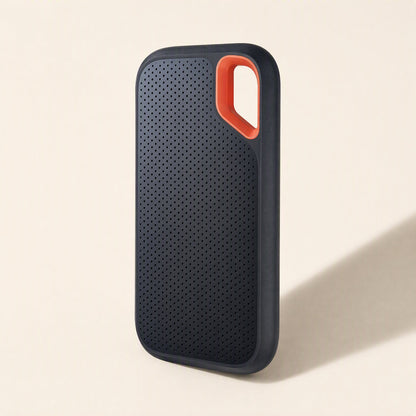 Roamdisk – Upright drive from a slight side angle, showing dotted black grip pattern and orange carabiner loop