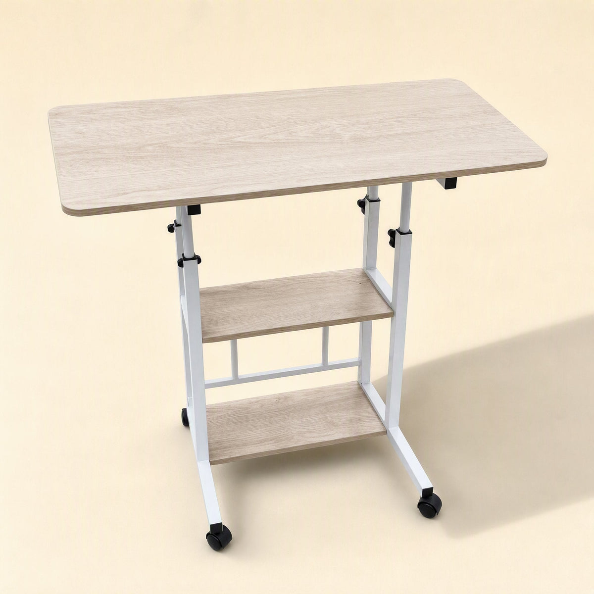 Rollrise Wheeled Adjustable Computer Desk in light oak with white frame and two shelves, angled view