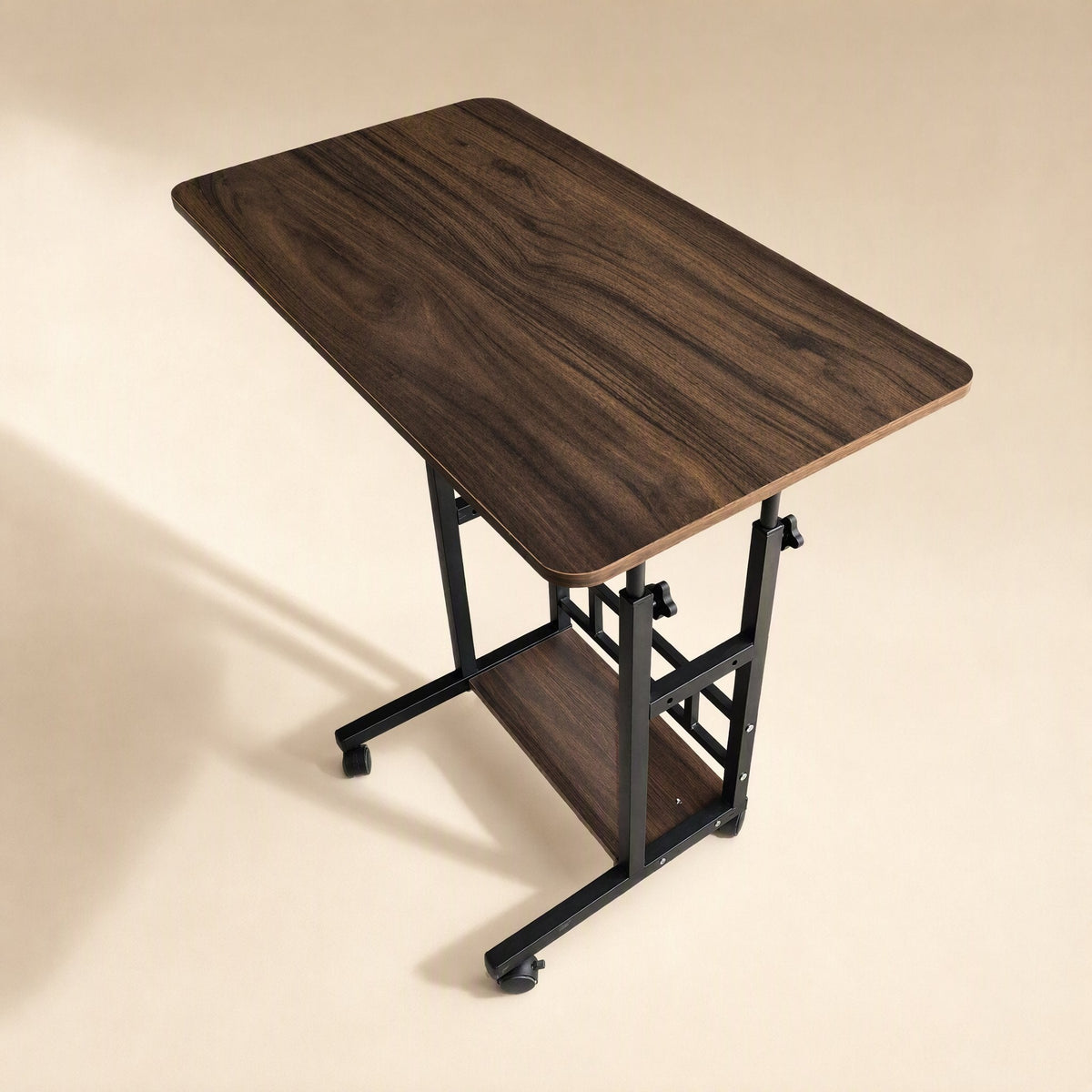 Rollrise – Walnut wood-grain desktop with black frame, casters and one shelf, shown from a high angle with soft shadow
