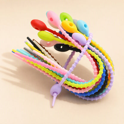 Cordtame Cable Organizer – bundle of colourful silicone ties arranged in an arch, with one lilac tie looped at the bottom