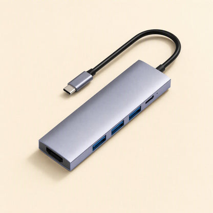 Dockbridge – Gray-lilac hub with HDMI port, three blue USB-A ports and a USB-C port, shown at an angle with cable