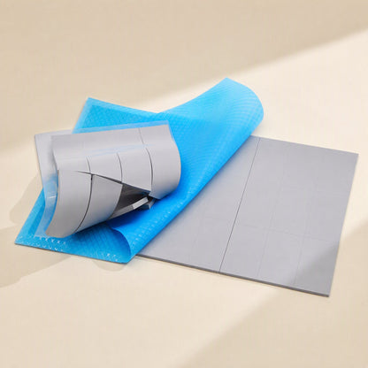 Heatguard High Temperature Silicone Sheet in gray with blue protective film being peeled back from the pad