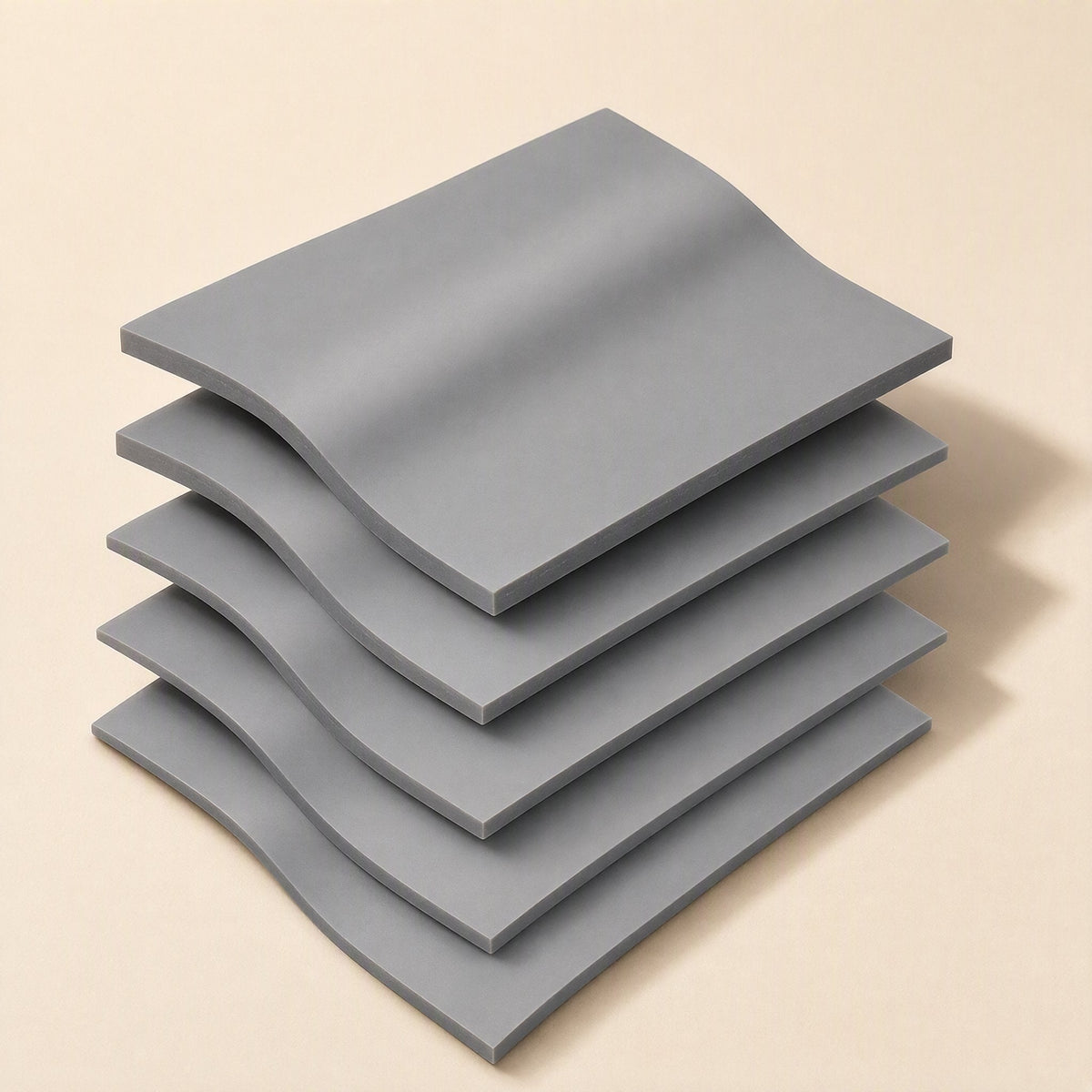 Heatguard High Temperature Silicone Sheet – stack of five gray silicone sheets with wavy, curved edges on a beige background