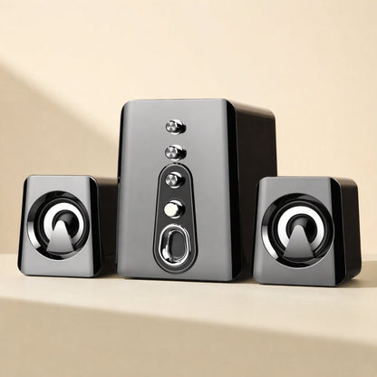 Deskchime – Gray 2.1 desktop speaker trio with a front-facing subwoofer and two cone-driver satellites on a beige ledge