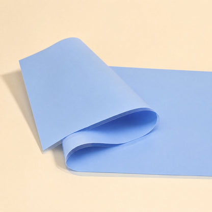 Thermaseal – Large blue silicone sheet with a clear liner folded over at the corner on a cream background