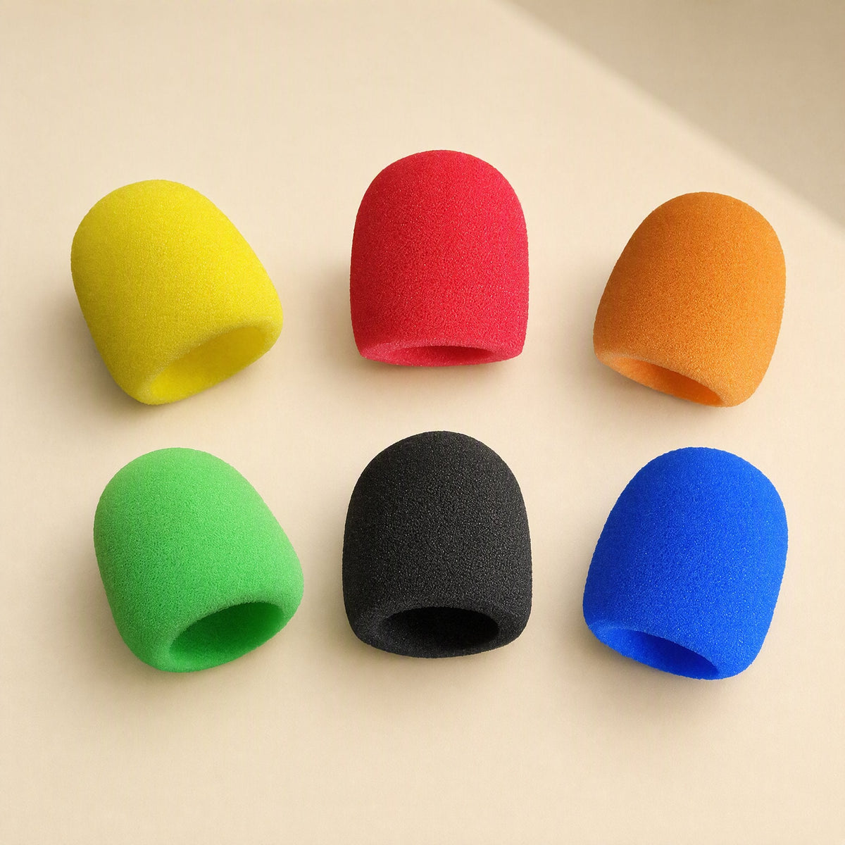 Spongehush Microphone Cover in yellow, red, orange, green, black and blue on a cream background