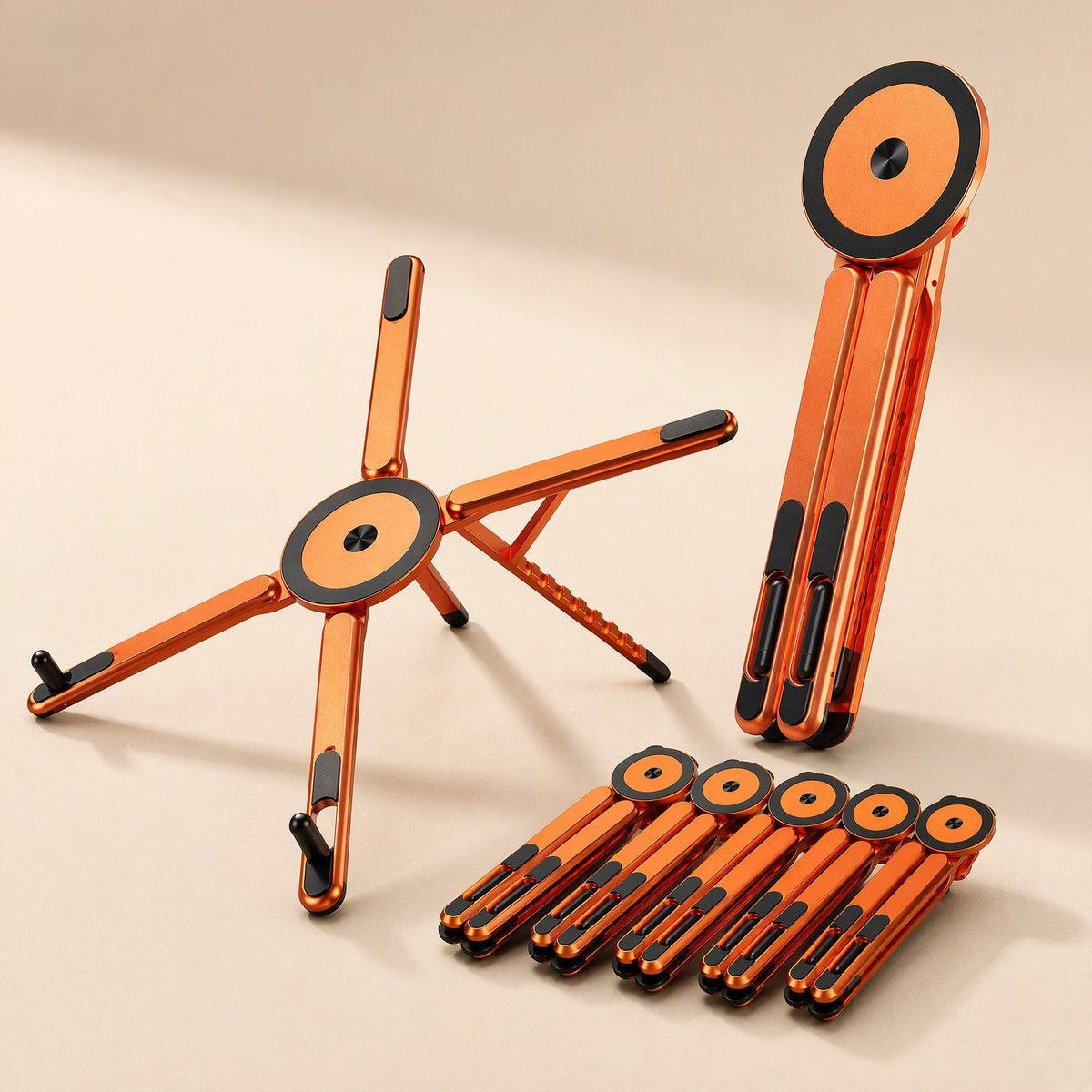 Magdesk Magnetic Aluminum Alloy Desktop Stand in orange, opened flat beside a folded one and five collapsed stands
