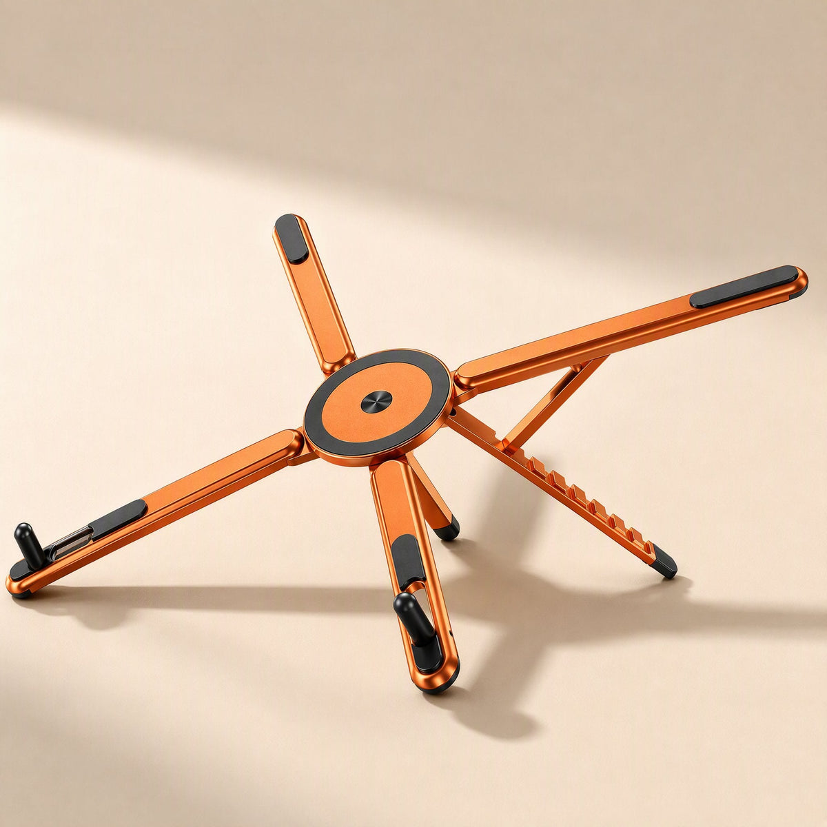 Magdesk – Orange star-shaped stand with magnetic black-and-orange disc at center, seen from a low side angle