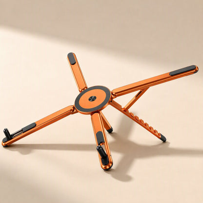 Magdesk – Orange star-shaped stand with magnetic black-and-orange disc at center, seen from a low side angle