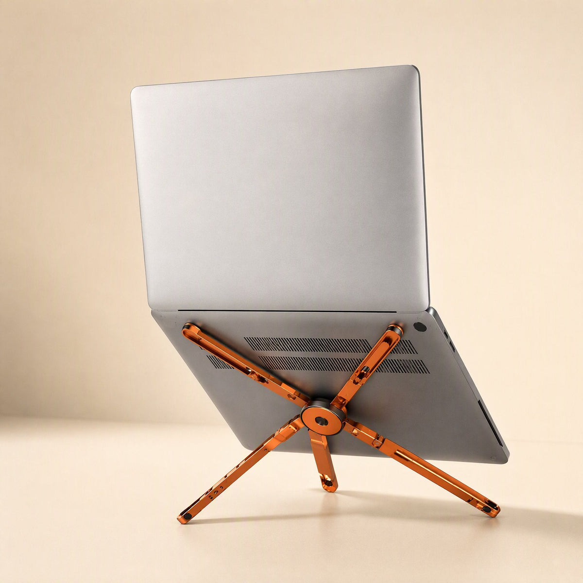 Magdesk – Silver laptop tilted on the orange stand, showing its legs spread against the underside of the laptop