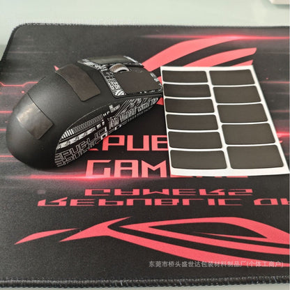 Tackmouse Mouse Anti-Slip Sticker pads on a black mouse beside a sheet of 11 grip pads on a red gaming mat
