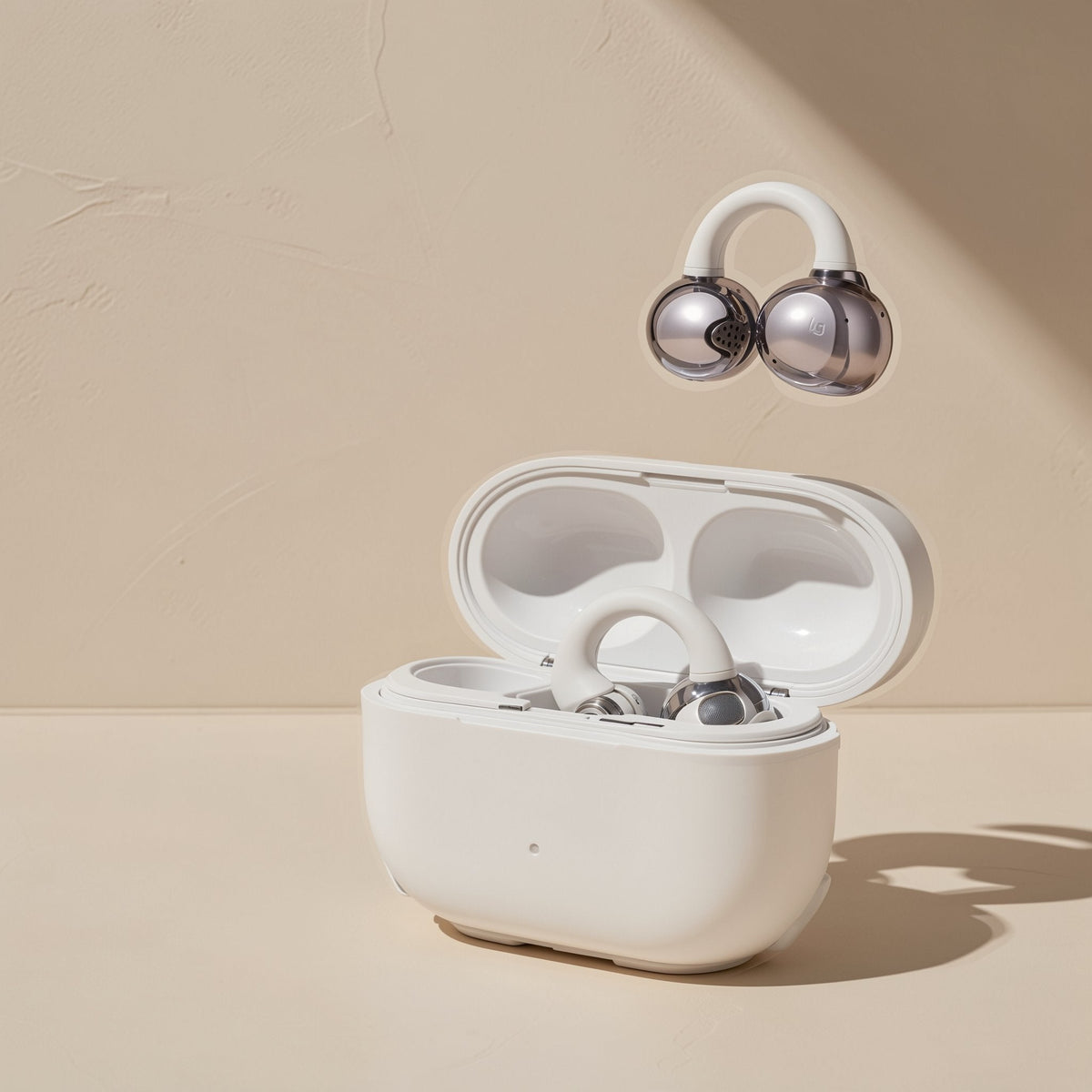 Clipbeat Clip-On Bluetooth Headphones in silver and white floating above an open white charging case