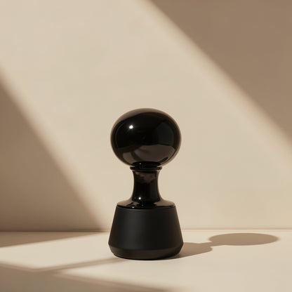 Clipbeat Clip-On Bluetooth Headphones – glossy black rounded stand with a bulbous top casting a shadow against a beige wall