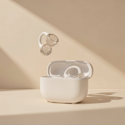 Clipbeat – Clip-on earbud with clear gray ear cups floating above an open cream charging case on a beige background