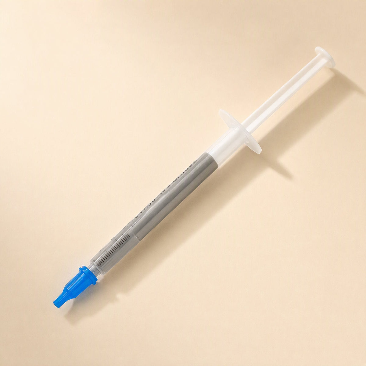 Heatbond – Syringe with the blue cap removed, showing the nozzle tip and printed scale on the barrel
