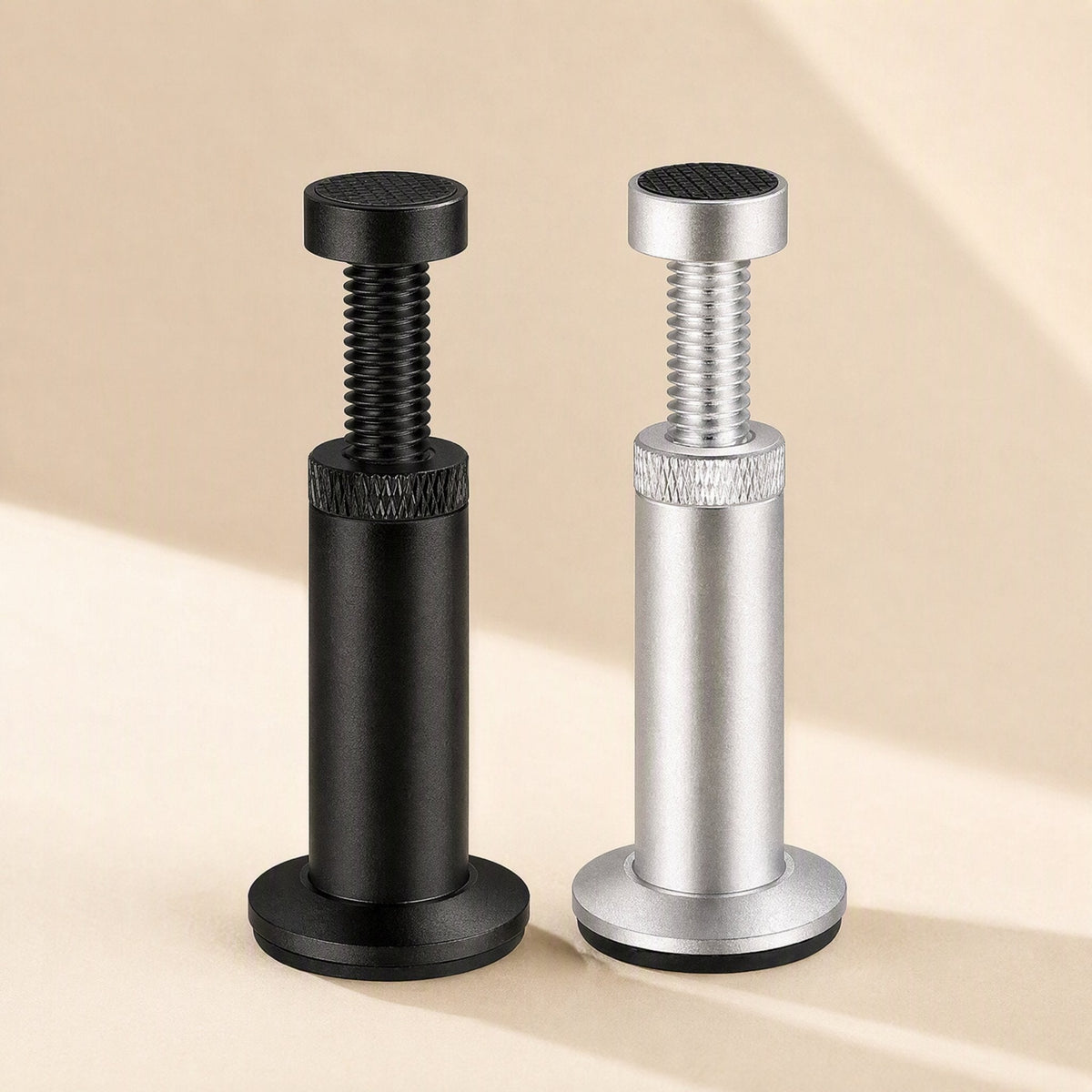 Magclamp – Black and silver adjustable support posts with knurled collars and threaded screw tops side by side on a beige