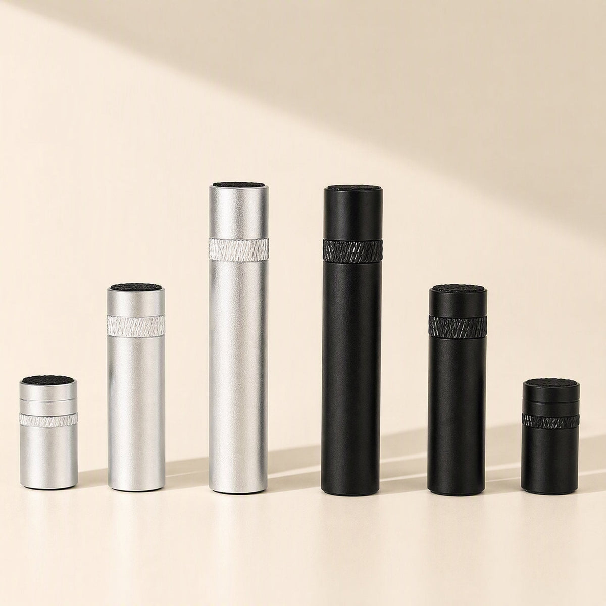 Magclamp – Row of six silver and black cylindrical posts in short, medium and tall sizes with knurled bands and textured tops