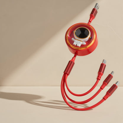 Pullcharge – Red retractable 3-in-1 cable with astronaut window, three woven tips curving across a beige surface